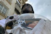 Cao Junjie poses for a picture with his two-month old baby inside a safety pod he created to protect his baby from the coronavirus disease in Shanghai