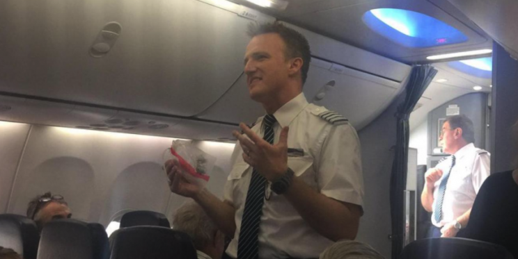 The pilot addressed passengers while holding the bird's bloodied remains (Picture: Eric Jackson/Twitter)