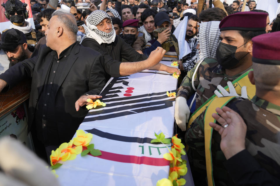 Members of an Iraqi Shiite militant group attend the funeral of a fighter with the Kataib Hezbollah, who was killed in a U.S. airstrike, in Baghdad, Iraq, Thursday, Jan. 25, 2024. (AP Photo/Hadi Mizban)