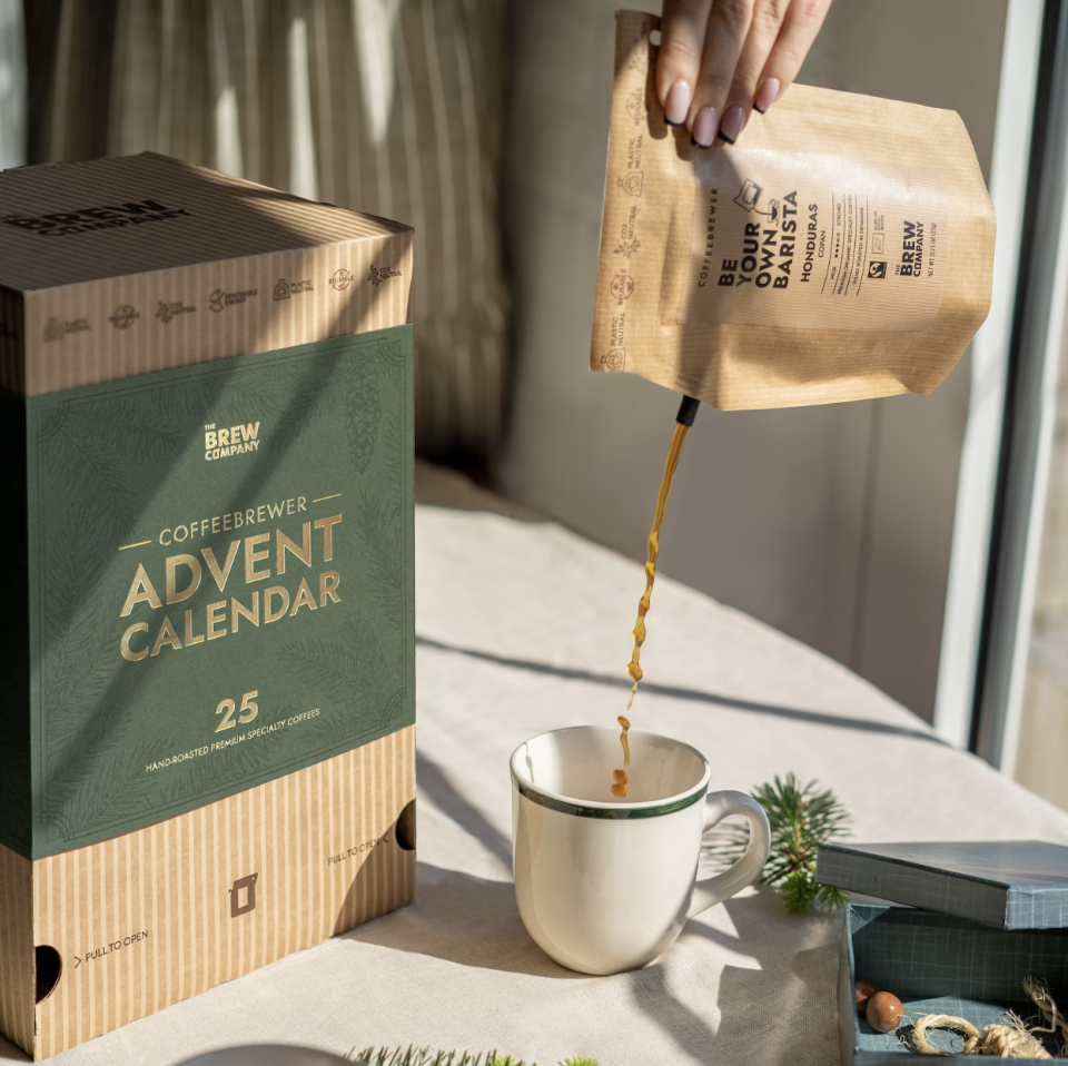 Specialty Coffee Advent Calendar 2022 in green and brown box on kitchen countertop with cup of coffee (Photo via Etsy)