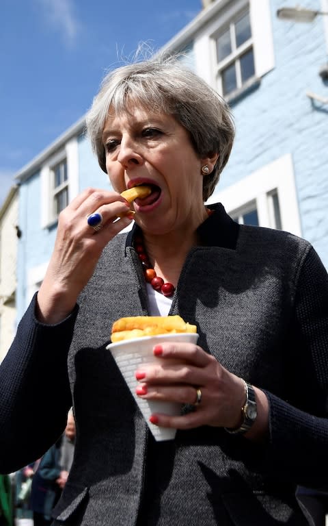 Britain's Prime Minister Theresa May enjoys some chips - Credit: DYLAN MARTINEZ 