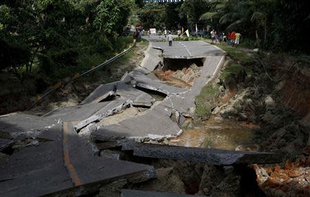 A view of a portion of a damaged highway in Getafe, Bohol a day after an earthquake hit central Philippines October 16, 2013. REUTERS/Erik De Castro