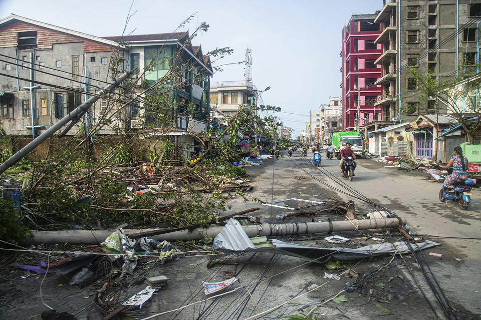 Locals ride motorbike while lamp-posts and trees are fallen after Cyclone Mocha in Sittwe township, Rakhine State, Myanmar, Monday, May 15, 2023. Rescuers on Monday evacuated about 1,000 people trapped by seawater 3.6 meters (12 feet) deep along western Myanmar's coast after the powerful cyclone injured hundreds and cut off communications. (AP Photo)