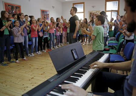 Members of children's choir "Superar" practise the songs that will be performed during the Pope's visit to Sarajevo at their music school in Srebrenica, Bosnia and Herzegovina May 23, 2015. Even before arriving in Sarajevo, Pope Francis has achieved a remarkable feat. Preparing for the visit, Bosnians of all faiths are showing a rare unity in a country plagued by political and ethnic tensions nearly 20 years after the end of its 1992-95 war that claimed over 100,000 lives. While the pontiff's June 6 visit is the most eagerly awaited by Catholic Croats, the smallest group in the ethnically segmented state, Orthodox Serbs and Muslim Bosniaks have also taken an active part in preparing a warm welcome for Francis. Picture taken May 23, 2015. REUTERS/Dado Ruvic