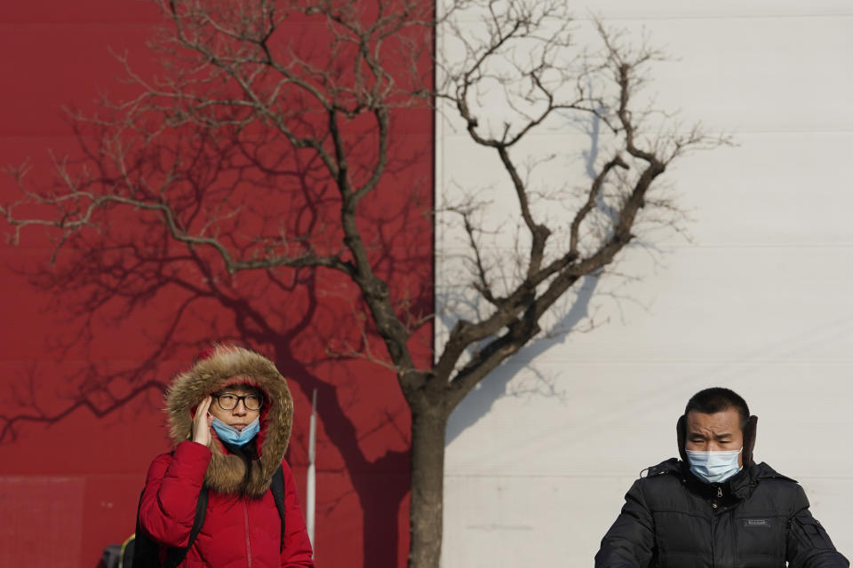 Residents wearing masks to protect from the coronavirus cross a junction in Beijing on Wednesday, Jan. 20, 2021. (AP Photo/Ng Han Guan)