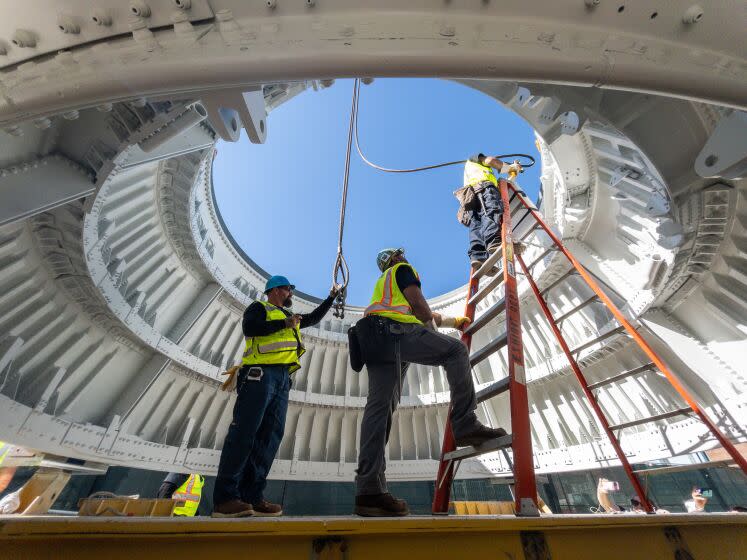 LOS ANGELES, CA - JULY 20: Crews attach cables to a Solid Rocket Booster aft skirt on Thursday, July 20, 2023. Two of these were placed onto seismic isolator pads at the site of the Samuel Oschin Air and Space Center at Exposition Park in Los Angeles, CA. This is the first step in a six-month process of stacking the solid rocket motors, the external tank and finally the space shuttle Endeavour. The vertical exhibit will be 183 feet tall when completed. (Myung J. Chun / Los Angeles Times)