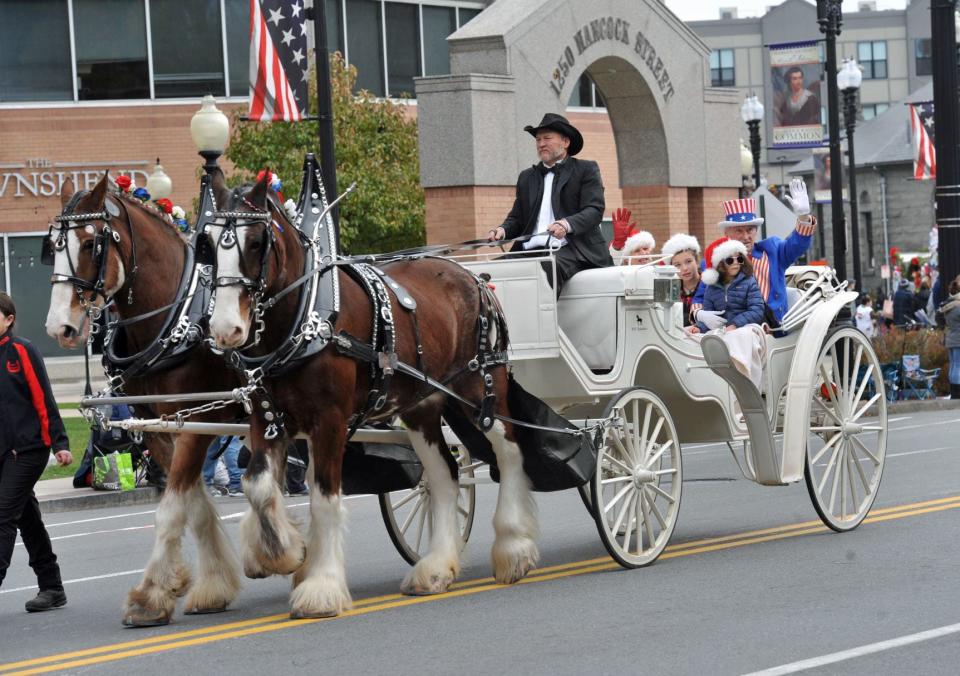Uncle Sam Rounseville, of Quincy, far right, rides in style with his family in a horse-drawn carriage during the 69th annual Quincy Christmas Parade, Sunday, Nov. 27, 2022.
