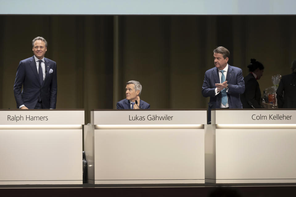 From left, Ralph Hamers, Chief Executive Officer of Swiss Bank UBS, gets a farewell applause from Lukas Gaehwiler, Vice Chairman of the Board of Directors and Colm Kelleher, Chairman of the Board of Directors during the general assembly of the UBS in Basel, Switzerland, Wednesday, April 5, 2023. (Georgios Kefalas/Keystone via AP)