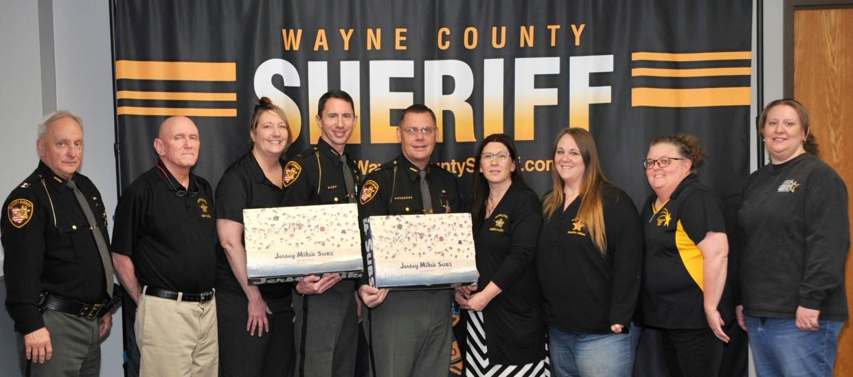 Wayne County Sheriff’s Office staff members Capt. Blaine Budd (left), Ed Griffie, Kristen Slicker, Lt. Michael Smucker, Sheriff Travis Hutchinson, Crystal Harper, Beth Farver, Jenny Marty and Rachel Fuqua get ready to enjoy sub sandwiches from Jersey Mike’s. Hutchinson treated his staff, and proceeds from the order went to help athletes attending the Special Olympics.