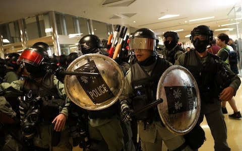 Riot police arrive to a shopping mall to disperse protesters during a rally against police brutality in Hong Kong - Credit: JEROME FAVRE/EPA-EFE/REX