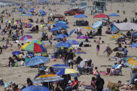 People enjoy the hot weather on Santa Monica Beach in Santa Monica, Calif., Wednesday, March 31, 2021. Half of the state's nearly 40 million people are now in the state's second-least restrictive orange tier amid low coronavirus case rates and increased vaccinations. Health officials in California and across the country are urging caution because of a troubling rise in new cases of COVID-19. (AP Photo/Damian Dovarganes)