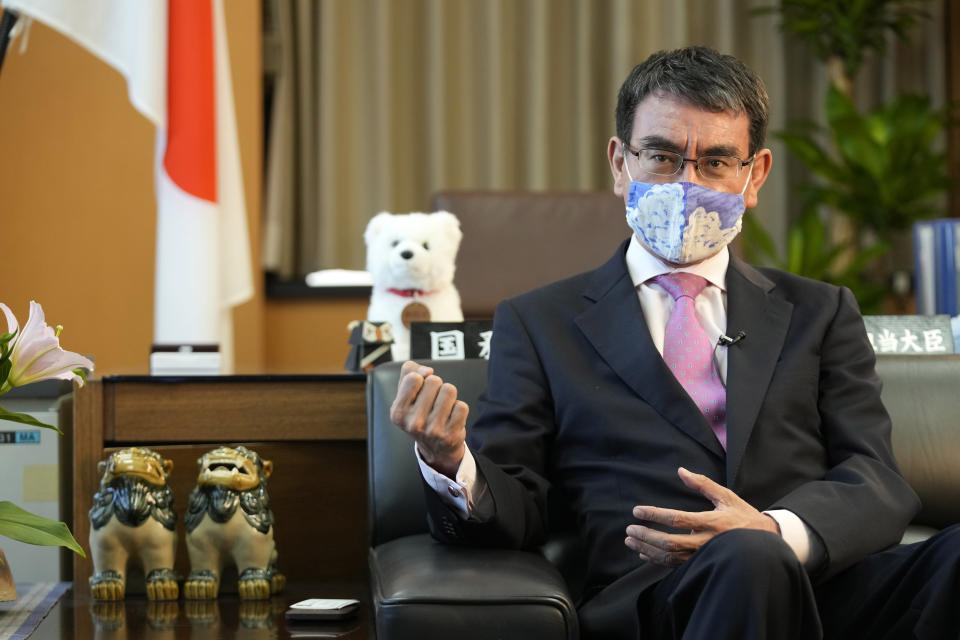 Taro Kono, Japan's minister in charge of a huge vaccination campaign, wearing a face mask speaks during an interview with The Associated Press at his office in Tokyo Wednesday, July 28, 2021. As Olympics host Tokyo saw another record number of coronavirus cases Wednesday, Kono told that the speed of the inoculation campaign, which is averaging about 10 million shots a week after a late start, is less urgent than getting shots to young people, who are blamed for spreading the virus. (AP Photo/Eugene Hoshiko)