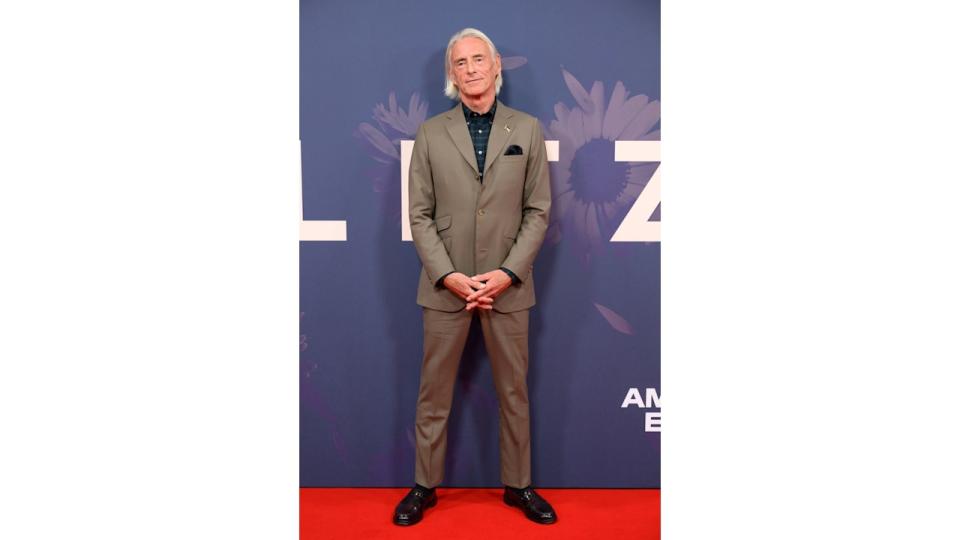 man posing on red carpet in suit 