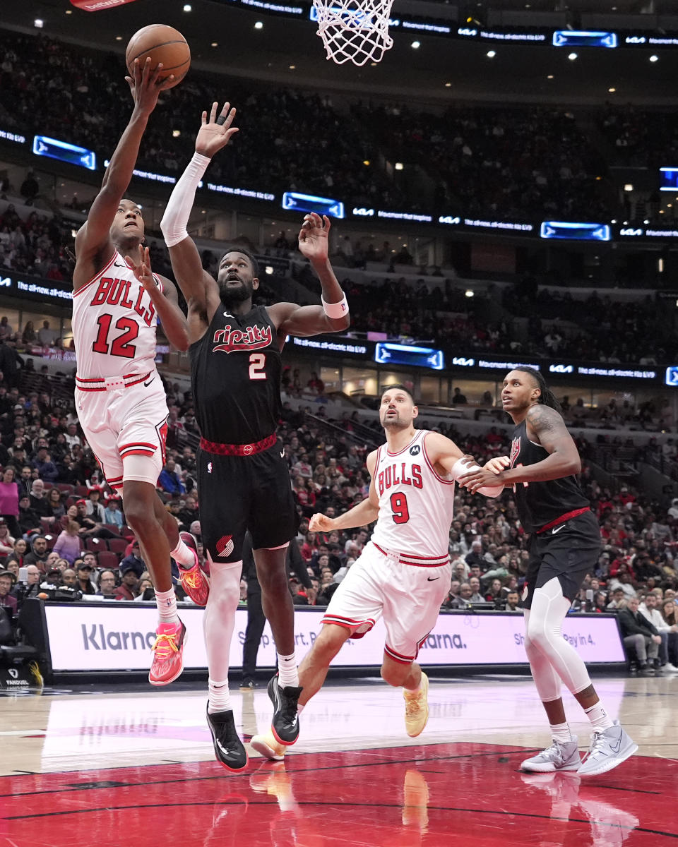 Chicago Bulls' Ayo Dosunmu (12) drives to the basket past Portland Trail Blazers' Deandre Ayton (2) during the first half of an NBA basketball game Monday, March 18, 2024, in Chicago. (AP Photo/Charles Rex Arbogast)