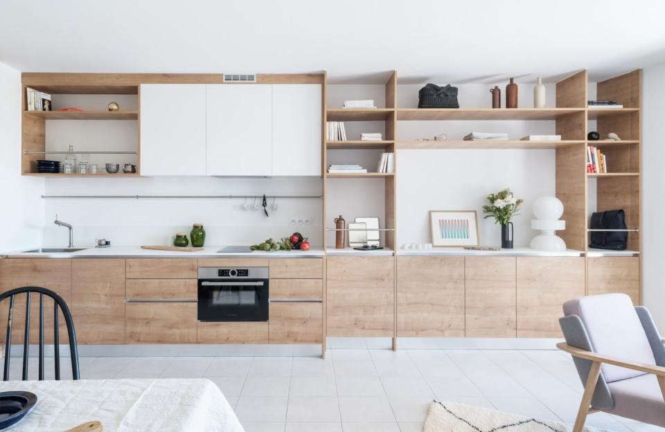 <p>Dans ce studio, la cuisine se fond dans une bibliothèque qui insuffle un style scandinave. Cette grande structure en bois permet de repousser les murs et le blanc d’agrandir la pièce tout en la structurant. Simple, minimaliste, design.</p><p>Architecte d’intérieur : <a href="https://www.houzz.fr/pro/ido44/studio-ido" rel="nofollow noopener" target="_blank" data-ylk="slk:Studio ido;elm:context_link;itc:0;sec:content-canvas" class="link ">Studio ido</a> - Aurélie Lesage</p><br>