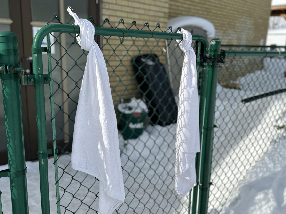 Like many others across Quebec, this daycare in Rouyn-Noranda tied white cloths to its gate to show solidarity with the daycare in Laval that was hit by a bus on Wednesday. (Mathieu Ouellette/Radio-Canada - image credit)