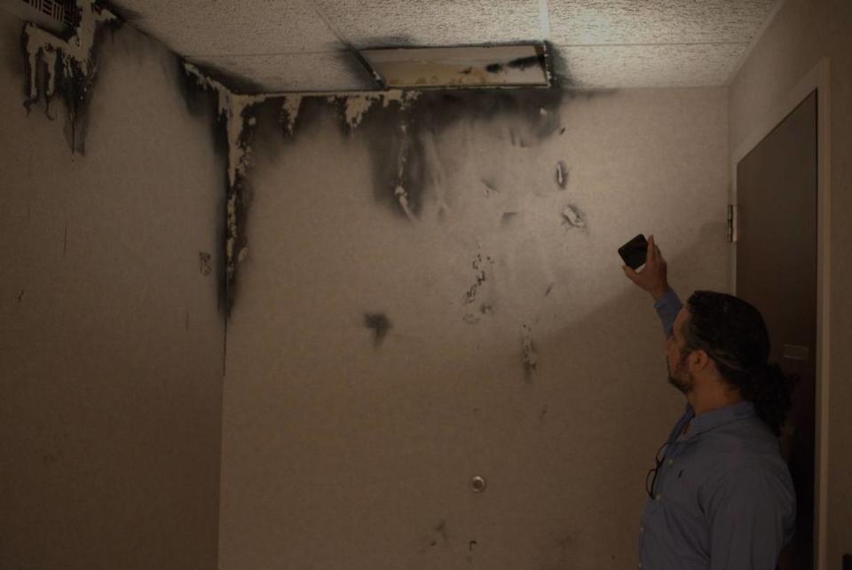 Eric Magnum, office manager of Moreno Family Dentistry in Kansas City, Kansas, shows an open ceiling tile apparently leading to an air vent inside the Brotherhood Building at 753 State Ave.