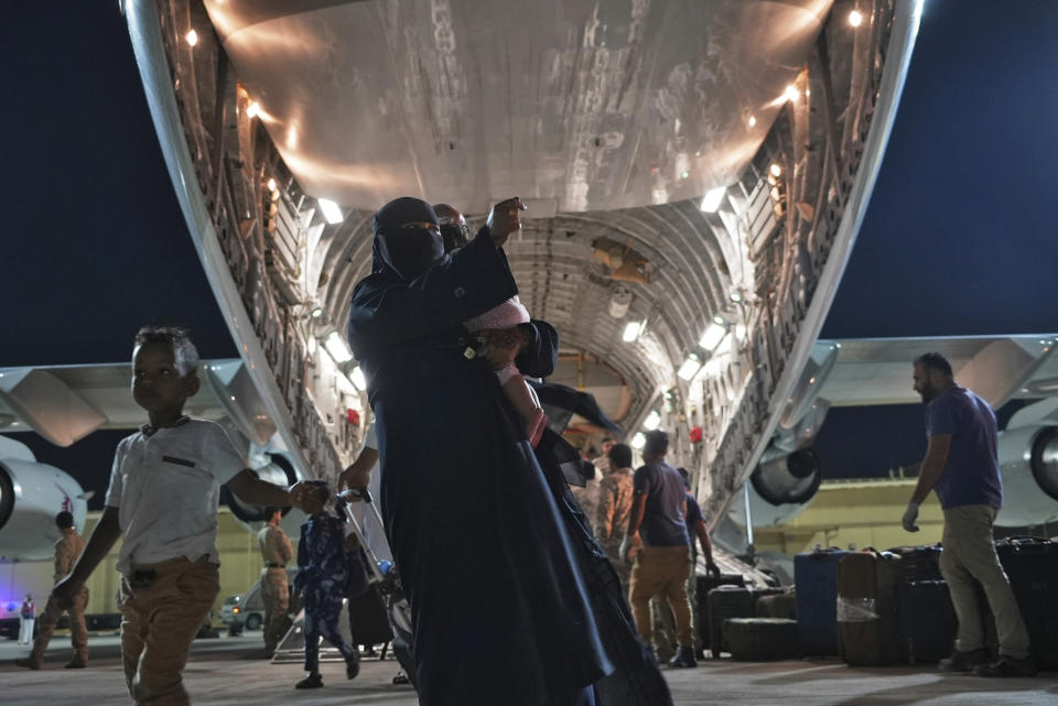 Evacuees flown out of Sudan disembark a Qatari C-17 Globemaster at Al Udeid Air Base, Qatar, Saturday, May 6, 2023. Qatar flew a relief flight into Sudan, carrying some 40 tons of food and leaving with 150 evacuees early Saturday as fighting continues between two generals vying for power in the African nation. (AP Photo/Lujain Jo)