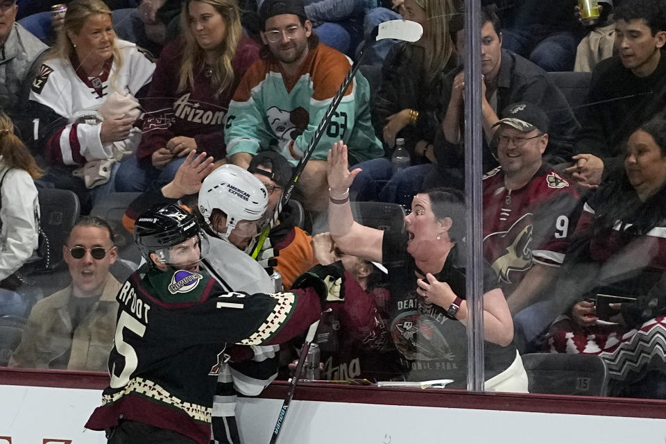 Arizona Coyotes center Alexander Kerfoot (15) checks Los Angeles Kings center Adrian Kempe into the boards during the third period of an NHL hockey game, Monday, Nov. 20, 2023, in Tempe, Ariz. (AP Photo/Matt York)