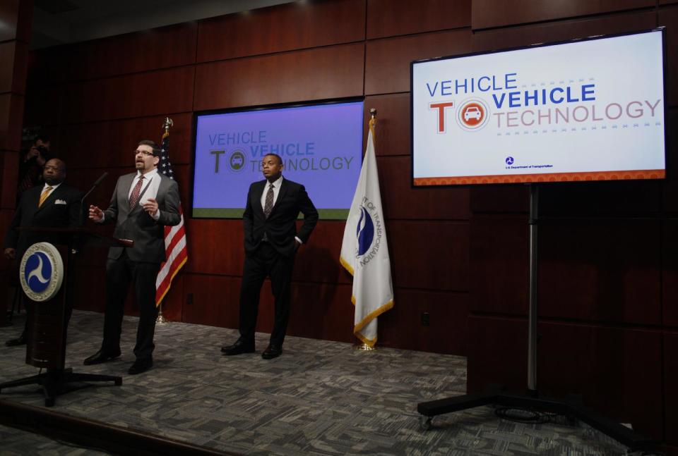 Transportation Secretary Anthony Foxx listens at right as National Highway Traffic Safety Administration Administration (NHTSA) Acting Administrator David Friedman, center, speaks about the Transportation Department's decision on vehicle-to-vehicle communication technology, Monday, Feb. 3, 2014, at the Transportation Department in Washington. Assistant Transportation Department Secretary for Research and Technology Greg Winfree is at left. . (AP Photo/Charles Dharapak)