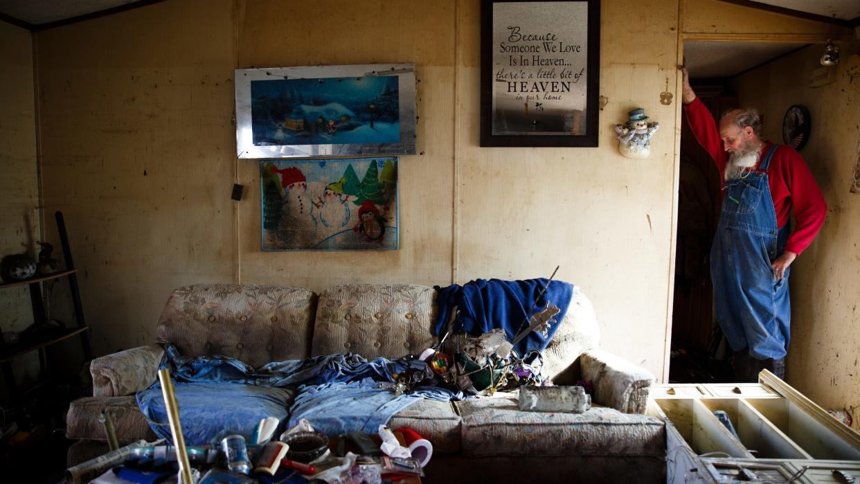 In this photo from Tuesday, April 16, 2019, Danny Manchester, 69, hangs his head on his arm as he stands in what was the living room of the trailer he and his wife, Mary, had lived in since 1993 in Pacific Junction. Flooding along the Missouri River in late March broke levees and inundated towns like Pacific Junction for weeks with water up to the rafters of homes. The couple said they weren't sure if they were going to rebuild there since they would have to start from scratch.