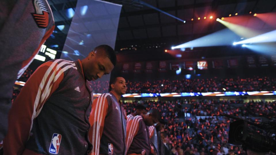 Portland Trail Blazers' including Damian Lillard honor coach Jack Ramsay whose number is spotlighted at top right prior to the first half of game six of an NBA basketball first-round playoff series game in Portland, Ore., Friday May 2, 2014. (AP Photo/Greg Wahl-Stephens)