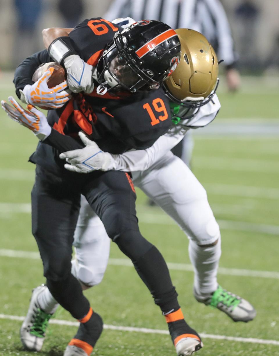 Massillon running back Kyler Wiggins is brought down in the second half by Hoban defender Payton Cook during this OHSAA Division II state semifinal game Friday, Nov. 25, 2022 at the University of Akron.