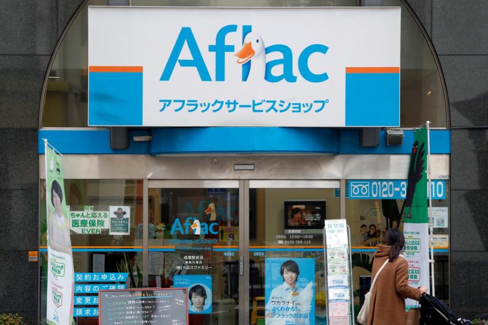 A woman looks at an Aflac storefront in Tokyo, Japan.