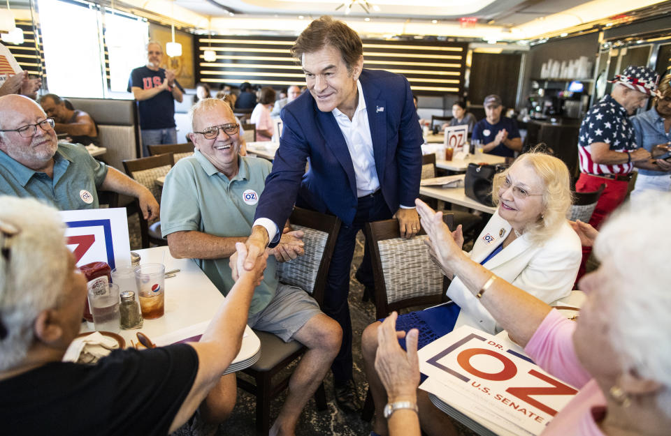 Republican nominee for U.S. Senate, Dr. Mehmet Oz, center, shakes hands with supporters at The Capitol Diner, Friday, Aug. 12, 2022, in Swatara Township, Pa. (Sean Simmers/The Patriot-News via AP)