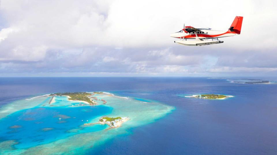 Sea plane flying above Maldives islands, Raa Atoll