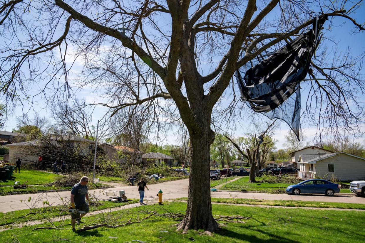 Residents clean up debris in Pleasant Hill, Saturday, April 27, 2024, after multiple tornados ripped across the state Friday evening.