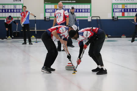 Keith Bulluck and Marc Bulger sweep a stone while teammate Michael Roos looks on at the USA Curling Men's Challenge Round in Blaine, Minnesota, U.S., January 3, 2019. All Pro Curling/Handout via REUTERS