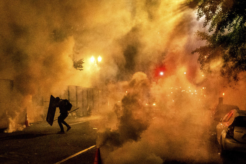 A Black Lives Matter protester uses a shield as federal officers use chemical irritants to disperse demonstrators at the Mark O. Hatfield United States Courthouse on Friday, July 24, 2020, in Portland, Ore. Since federal officers arrived in downtown Portland in early July, violent protests have largely been limited to a two block radius from the courthouse. (AP Photo/Noah Berger)