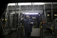 A worker disinfects a public bus against coronavirus in the city of Ahvaz in southwestern, Iran, in early morning of Tuesday, Feb. 25, 2020. Iran's government said Tuesday that more than a dozen people had died nationwide from the new coronavirus, rejecting claims of a much higher death toll of 50 by a lawmaker from the city of Qom that has been at the epicenter of the virus in the country. (Alireza Mohammadi/ISNA via AP)