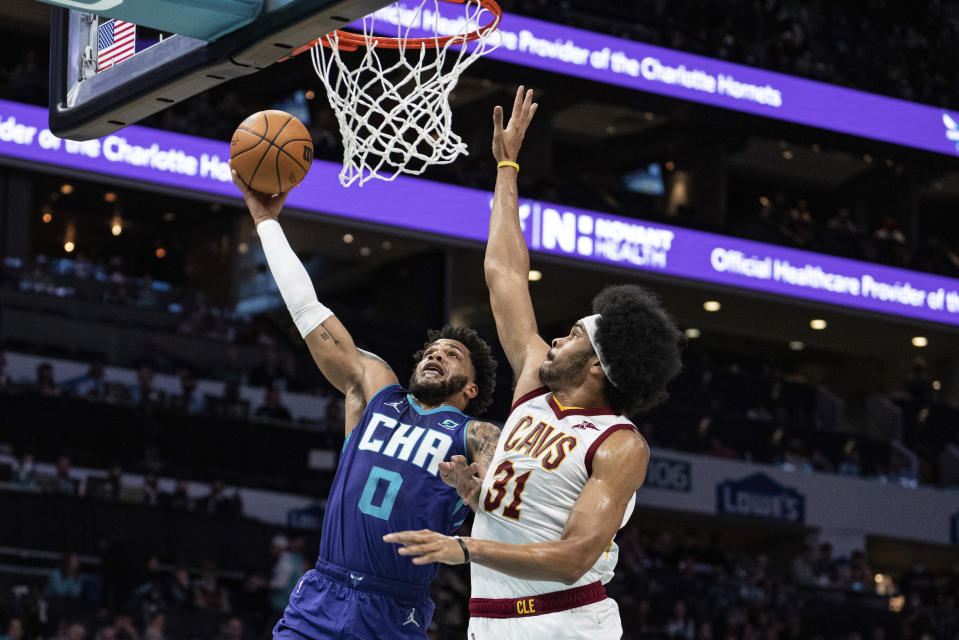 Charlotte Hornets forward Miles Bridges (0) drives to the basket while guarded by Cleveland Cavaliers center Jarrett Allen (31) during the first half of an NBA basketball game in Charlotte, N.C., Friday, Feb. 4, 2022. (AP Photo/Jacob Kupferman)