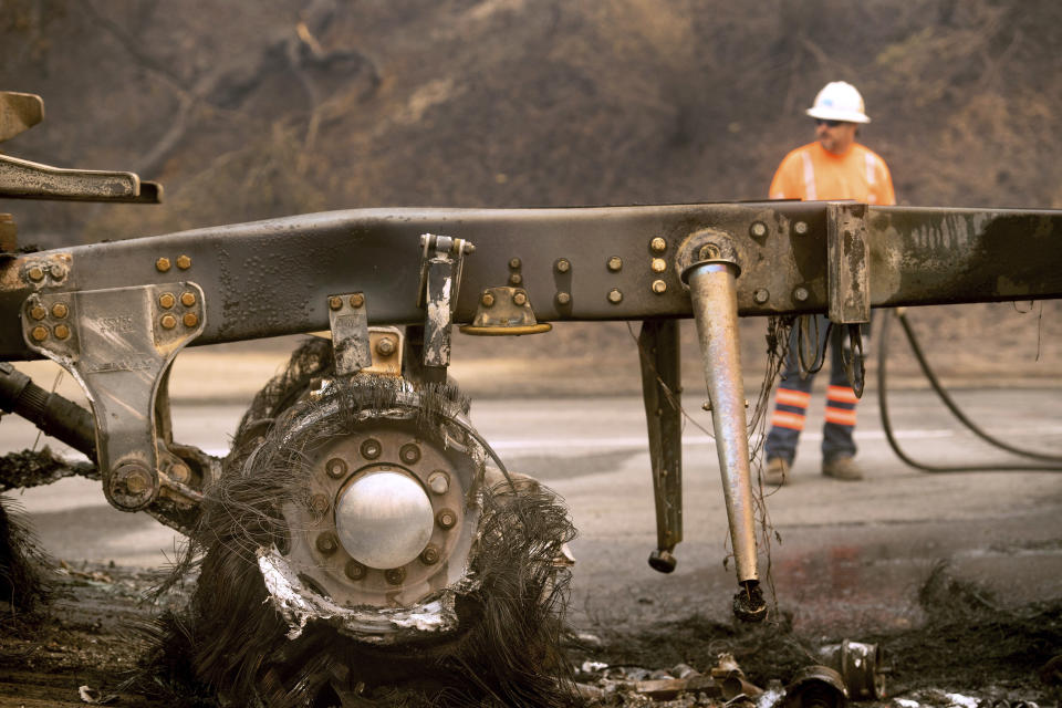 A scorched truck rests on Interstate 5 as the Delta Fire burns in the Shasta-Trinity National Forest, Calif., on Thursday, Sept. 6, 2018. The highway remains closed to traffic in both directions as crews battle the blaze. (AP Photo/Noah Berger)