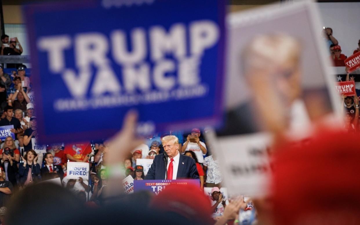 Donald Trump with Trump-Vance campaign banners