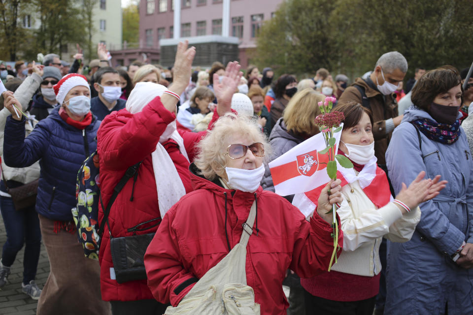 People, most of them pensioners, hold old Belarusian national flags march during an opposition rally to protest the official presidential election results in Minsk, Belarus, Monday, Oct. 26, 2020. Factory workers, students and business owners in Belarus have started a general strike, calling for authoritarian President Alexander Lukashenko to resign after more than two months of mass protests triggered by a disputed election. (AP Photo)