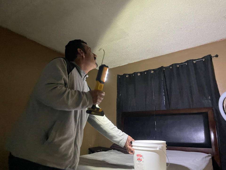 Renter Jose Alvarez looks at streams of water pouring into his family's bedrooms as they tried to salvage belongings from the South San Francisco apartment building which had its roof partially blown off by wind gust in San Francisco Wednesday, Jan. 11, 2023. (AP Photo/Haven Daley)