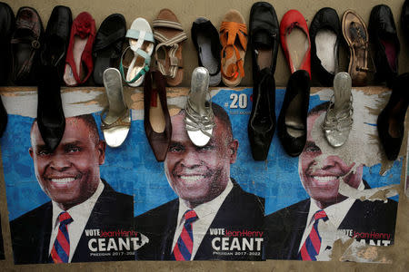 Posters of presidential candidate Jean-Henry Ceant, of Renmen Haiti (Love Haiti) Party, are seen on a wall behind shoes on display for sale in a streett of Port-au-Prince, Haiti, November 18, 2016. REUTERS/Andres Martinez Casares