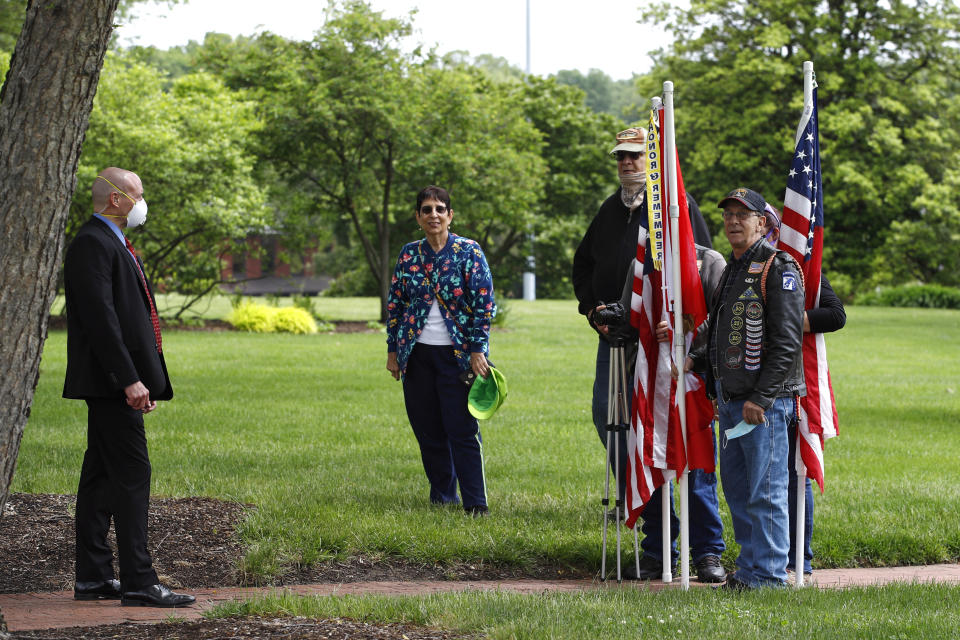 Visitors watch near a member of the U.S. Secret Service as Democratic presidential candidate, former Vice President Joe Biden and Jill Biden visit the Delaware Memorial Bridge Veterans Memorial Park to lay a wreath, Monday, May 25, 2020, in New Castle, Del. (AP Photo/Patrick Semansky)