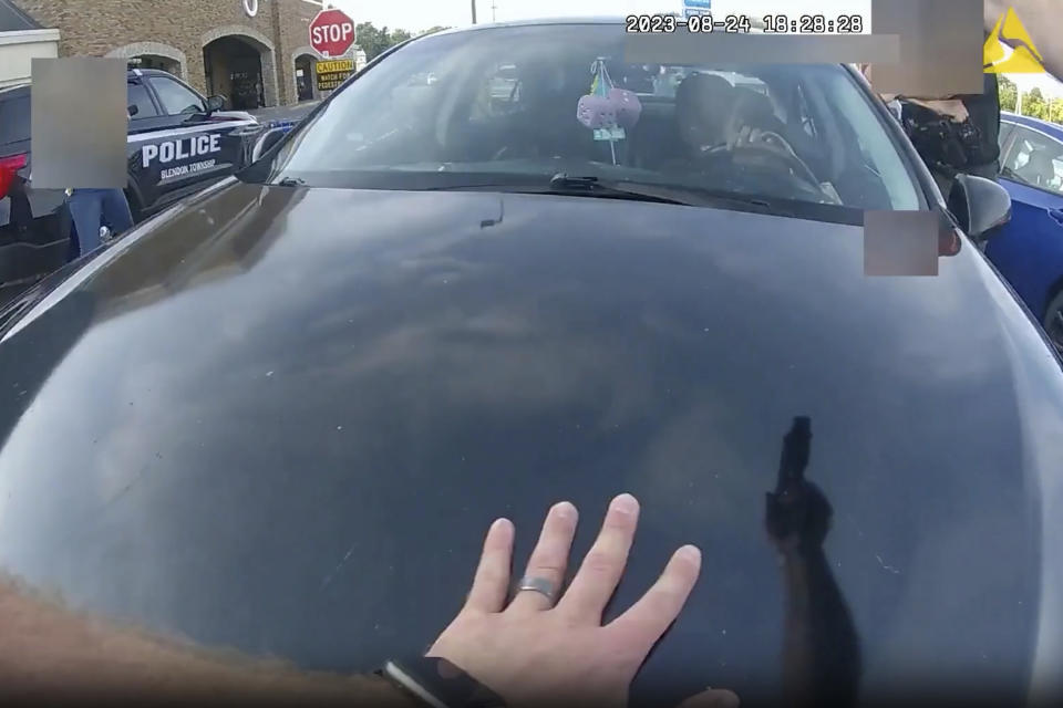 FILE - This image from bodycam video released by the Blendon Township Police on Friday, Sept. 1, 2023, shows an officer pointing his gun at Ta'Kiya Young moments before shooting her through the windshield outside a grocery store in Blendon Township, Ohio, a suburb of Columbus, on Aug. 24. The pregnant Black mother was pronounced dead shortly after the shooting. Her unborn daughter did not survive. The image was pixelated by the source. (Blendon Township Police via AP, File)