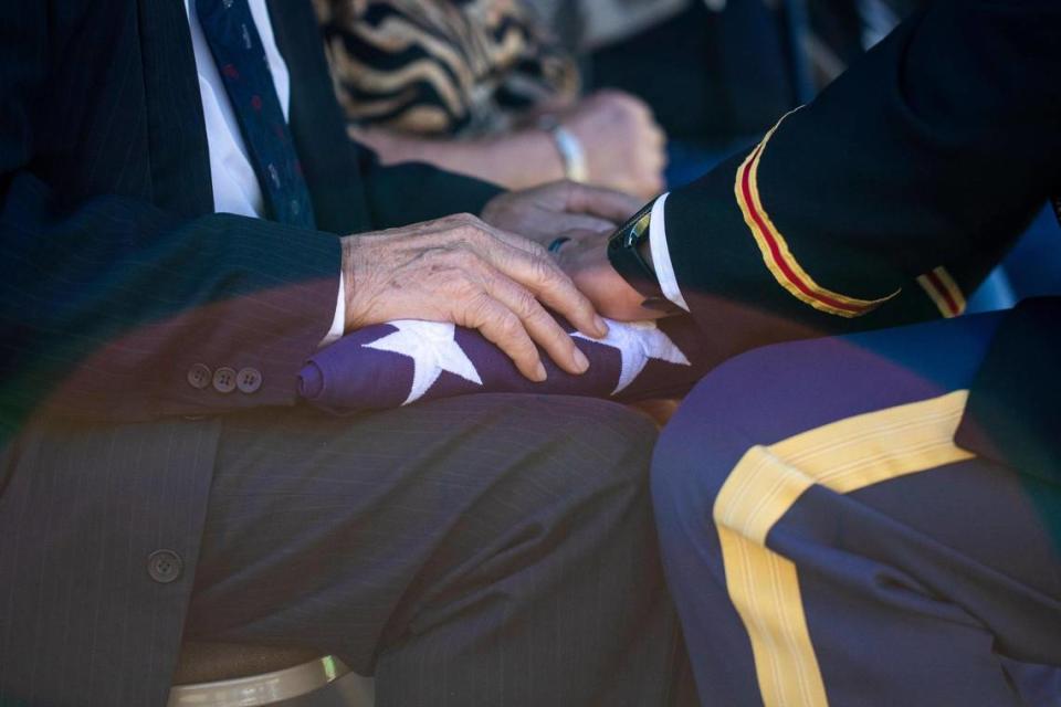 A member of the honor guard gives the flag from the casket of Army Pfc. Berton J. McQueen to his nephew Bert Griffen, 76, during a full military funeral at the Wind Cave Baptist Church in Jackson County outside McKee, Ky., Saturday, October 16, 2021. McQueen died in France in 1944 during World War II and his body was not identified until July 2021, 76 years later.