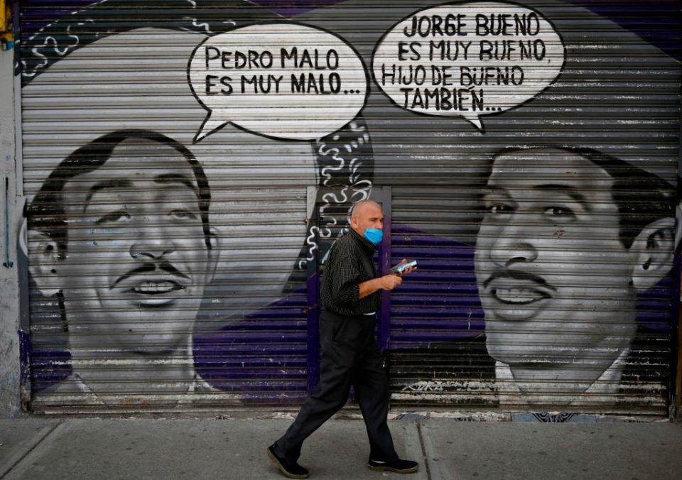 Un hombre pasa frente a un grafiti