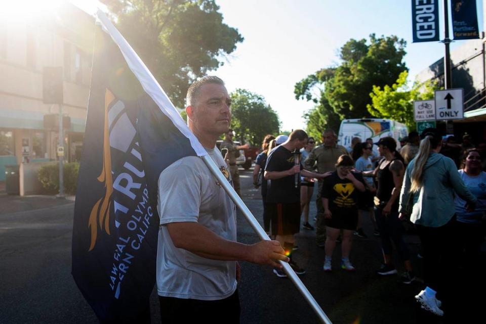 Special Olympics Northern California Regional Director Jeff Godfrey, holds a flag near Bob Hart Square after completing the Law Enforcement Torch Run for Special Olympics Northern California in Merced, Calif., on Thursday, June 15, 2023. Andrew Kuhn/akuhn@mercedsun-star.com