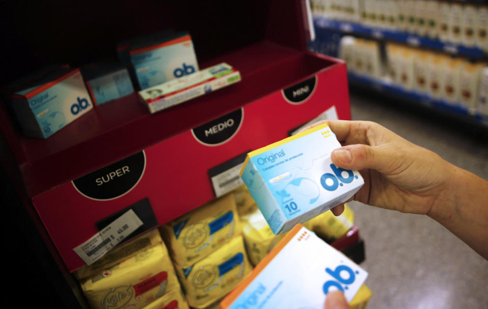 A woman takes tampon boxes out of a supermarket shelf in Buenos Aires January 16, 2015. Argentines have been complaining for a while now about the country's product shortages. And, until recently, the government has managed to brush aside such complaints, which have centered around Argentina's import restrictions. Well until, that is, the country's 20.6 million women couldn't find their favorite tampons earlier this month, during the height of summer. REUTERS/Marcos Brindicci (ARGENTINA - Tags: POLITICS BUSINESS SOCIETY)