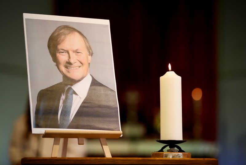 A candle and a portrait of British MP David Amess are seen at the church of St Michael's and all Angels, in Leigh-on-Sea