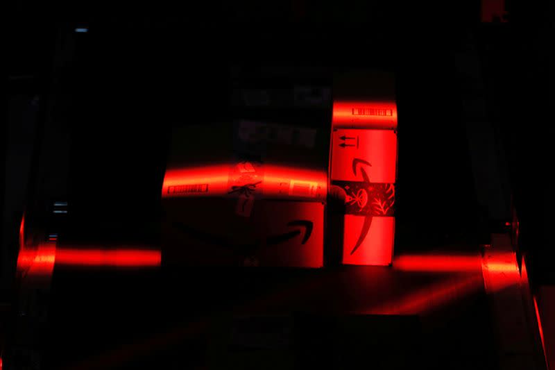 FILE PHOTO: Amazon packages are scanned by a robotic scanner as they travel on conveyor belts inside of an Amazon fulfillment center on Cyber Monday in Robbinsville, New Jersey