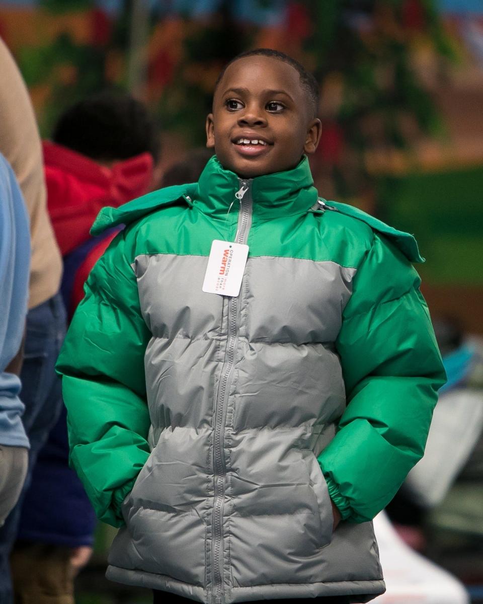 Fifty local volunteers help students try on their coats, picking out their favorite color and size, as part of Operation Warm, which provides the entire student body at Warner Elementary School with brand-new coats, in 2018.