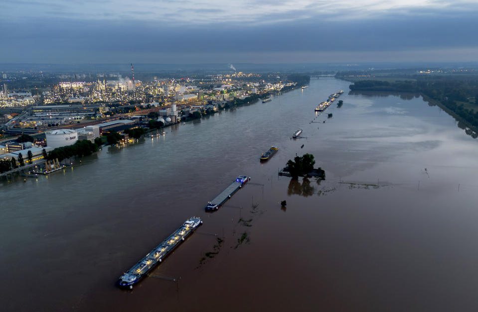 Cargo ships park at the bank of the river Rhine near the BASF chemical plant in Ludwigshafen, Germany, Tuesday, June 4, 2024. The Rhine left its banks after heavy rain falls in southern Germany during the last days. (AP Photo/Michael Probst)